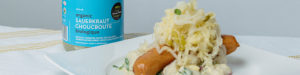 Jar of sauerkraut and sauerkraut on a sausage